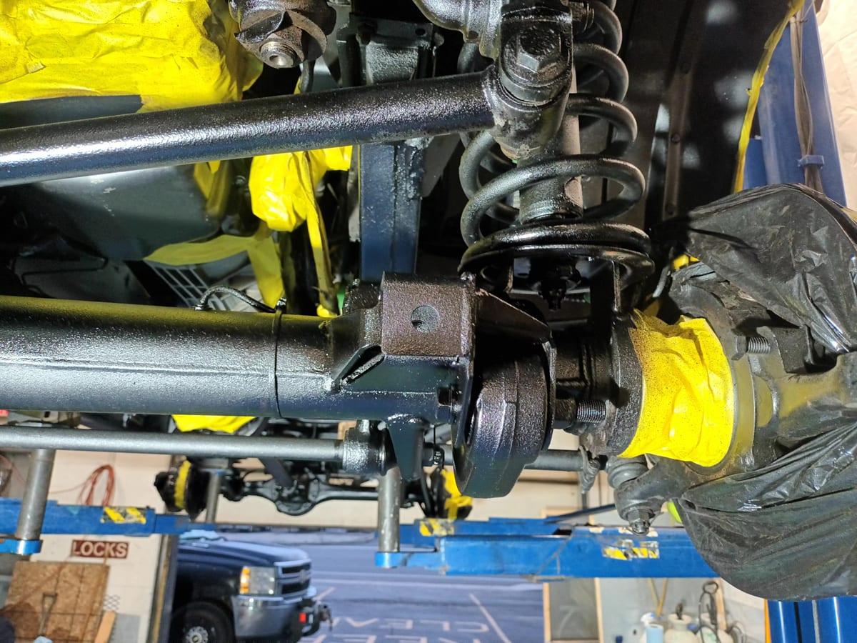 Coated Defender axle, coil spring, and radius arms with the driveshaft masked off