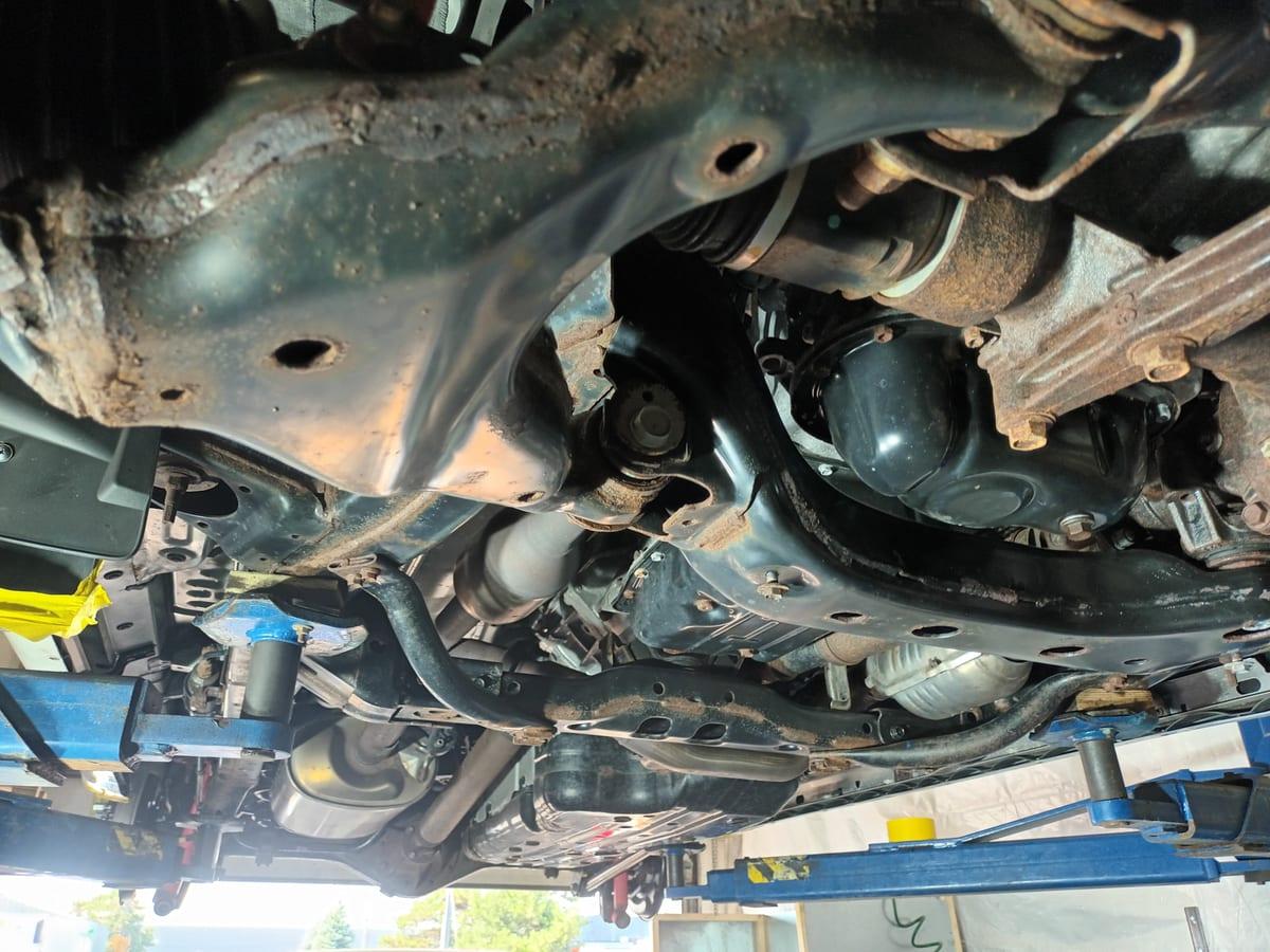 4Runner underbody part way through a dry ice blast, cleaned frame rail beside untouched surface rust